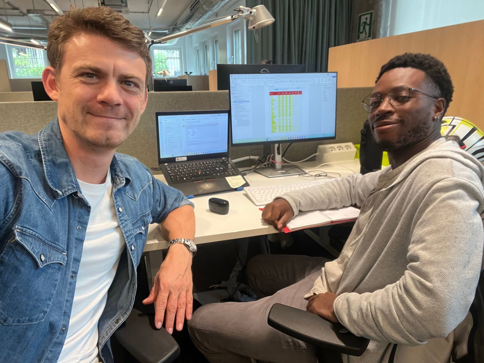 Two benchmarking analysts working together at a desk with salary data on screen