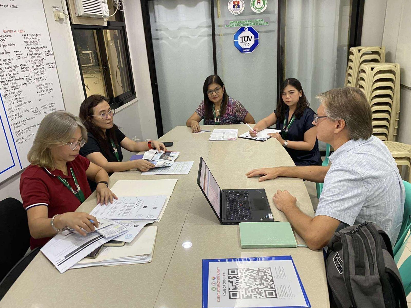A remuneration analyst interviewing an employer's HR team around a meeting table