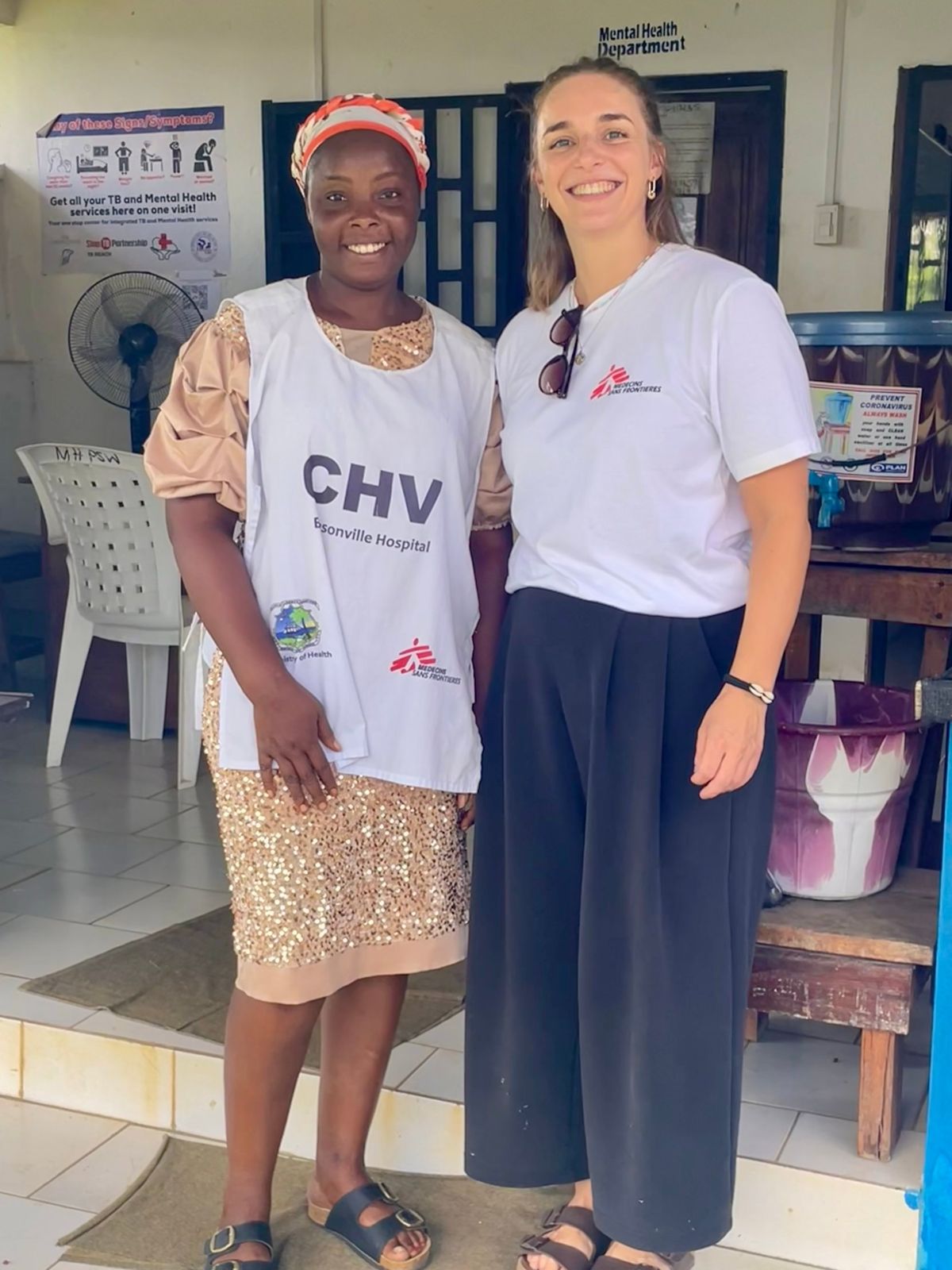An MSF analyst with a community health volunteer outside a hospital mental health department