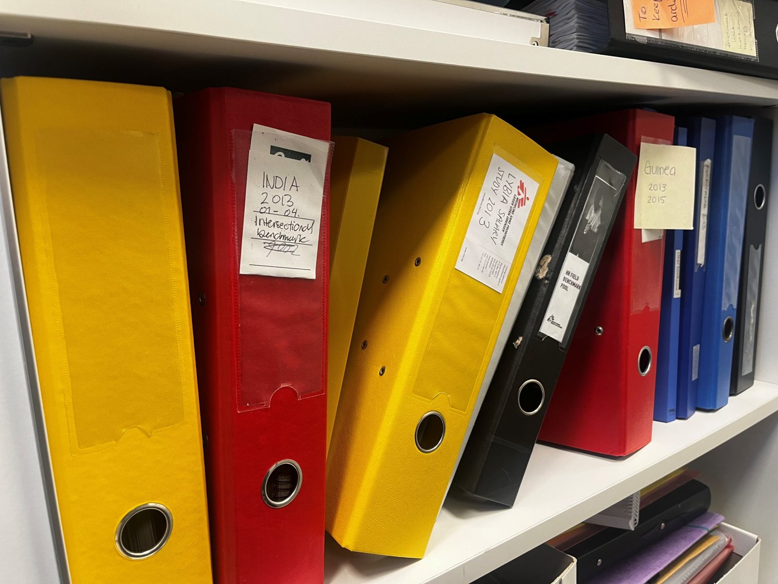 Shelves of printed MSF benchmark studies in labelled binders